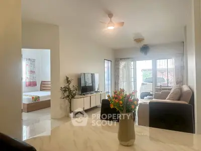 Spacious living room with modern decor and adjacent bedroom in a cozy home.
