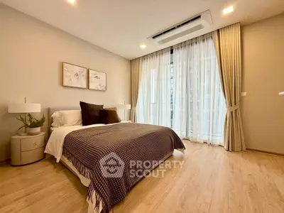 Elegant bedroom with modern decor and large window in a stylish apartment.