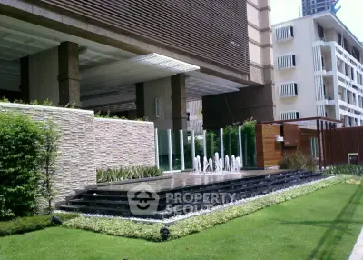 Luxurious building entrance with modern water feature and landscaped garden