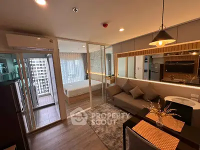 Modern condo interior with open living room and bedroom, featuring stylish decor and city view balcony.