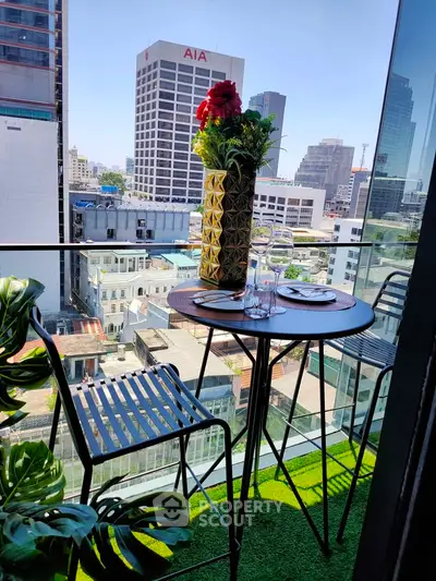 Chic urban balcony with stunning city view, perfect for relaxation and dining.