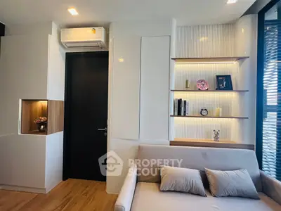 Modern living room with sleek design and built-in shelves, featuring cozy sofa and stylish decor.