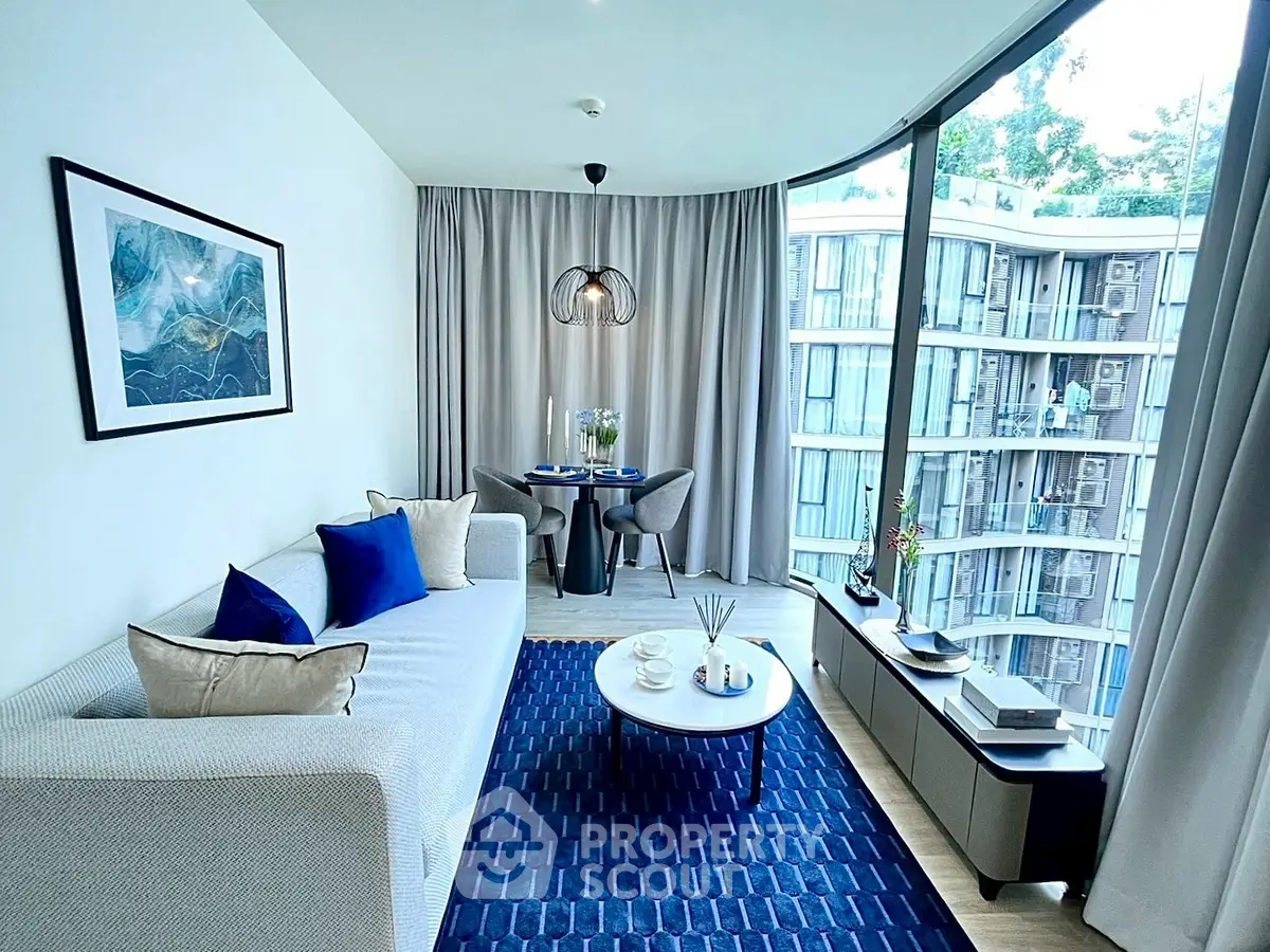 Modern living room with floor-to-ceiling windows and stylish decor in urban apartment.