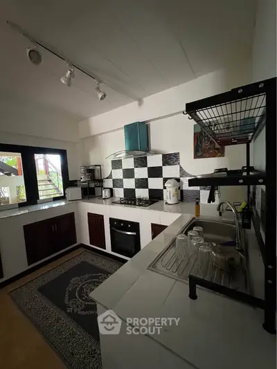Charming kitchen with modern appliances and open layout, featuring stylish backsplash and ample natural light.