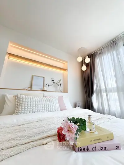 Cozy bedroom with modern decor and natural light, featuring stylish lighting and elegant bedding.