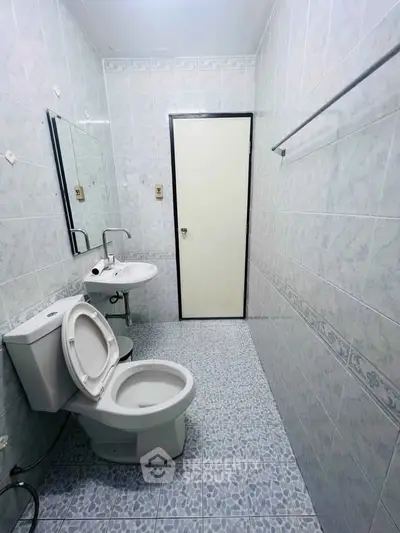 Spacious bathroom with modern fixtures and tiled walls, perfect for a refreshing start to your day.