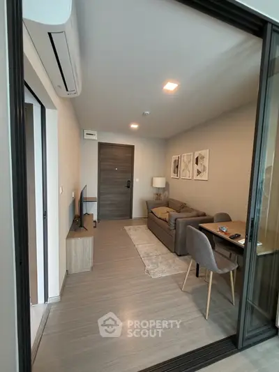 Modern living room with cozy sofa and dining area, featuring stylish decor and wooden flooring.