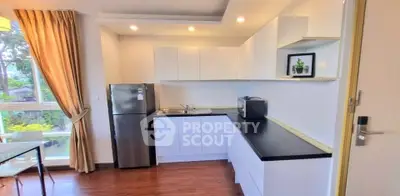 Modern kitchen with sleek white cabinets and stainless steel fridge in bright apartment