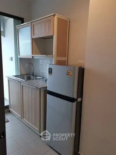 Compact kitchen with fridge and sink in modern apartment