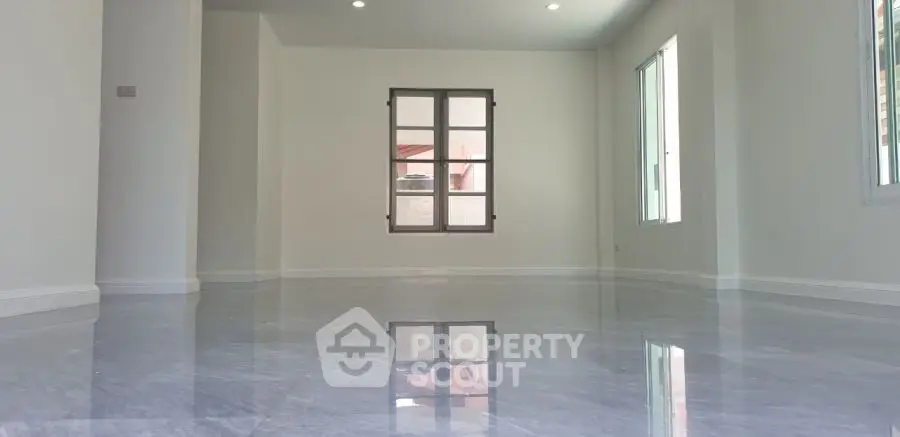 Spacious empty room with glossy marble flooring and large windows