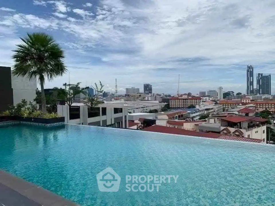 Stunning rooftop pool with panoramic city views and lush greenery.
