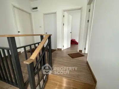Spacious hallway with modern wooden flooring and sleek railing design