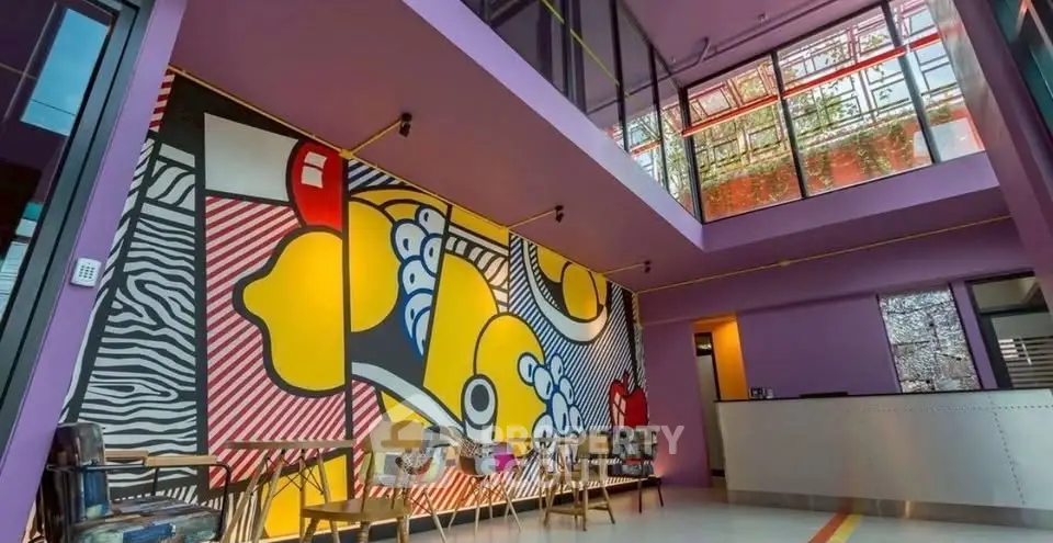 Vibrant lobby with modern art mural and colorful seating in a contemporary building.