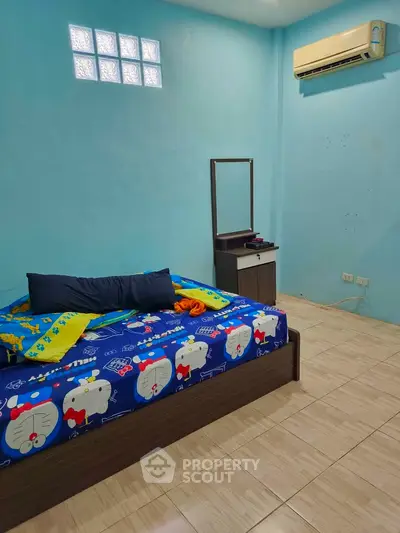 Cozy bedroom with air conditioning and colorful bedding in a bright blue room.