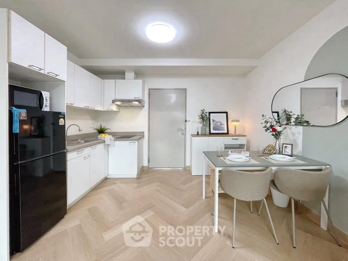 Modern kitchen with sleek cabinets and dining area, featuring elegant decor and bright lighting.