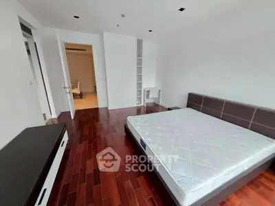 Spacious bedroom with hardwood floors and modern furniture