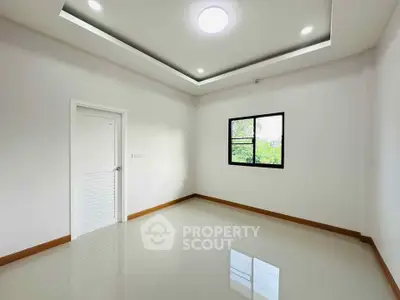 Spacious empty room with modern ceiling lights and large window
