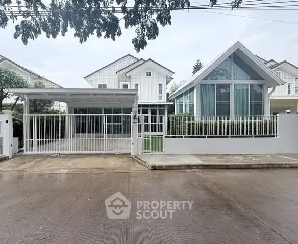 Modern white house with sleek design and spacious driveway in a serene neighborhood.