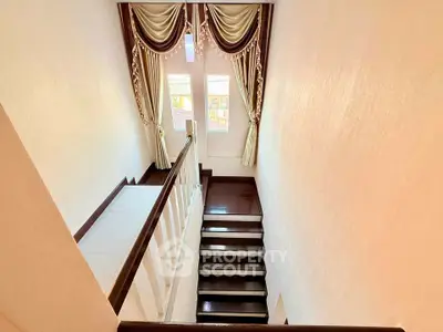 Elegant staircase with luxurious drapes and natural light