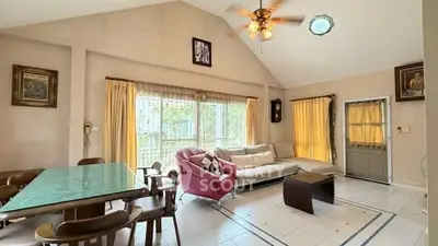 Spacious living room with high ceiling and large windows in a modern home.