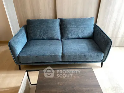Modern blue sofa in stylish living room with wooden accents and coffee table.