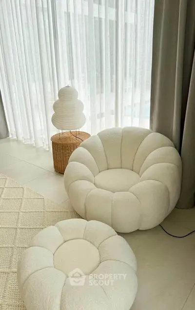 Elegant modern living room with plush white chairs and soft lighting