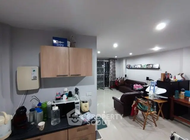 Spacious living room with modern kitchen appliances and cozy seating area.