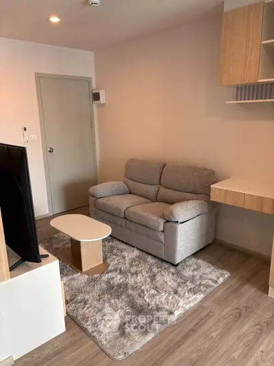 Cozy living room with modern decor and plush gray sofa in a stylish apartment.