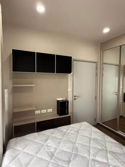 Modern bedroom with sleek storage and mirrored closet doors