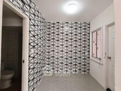 Modern bathroom with stylish black and white tile design and sleek fixtures.