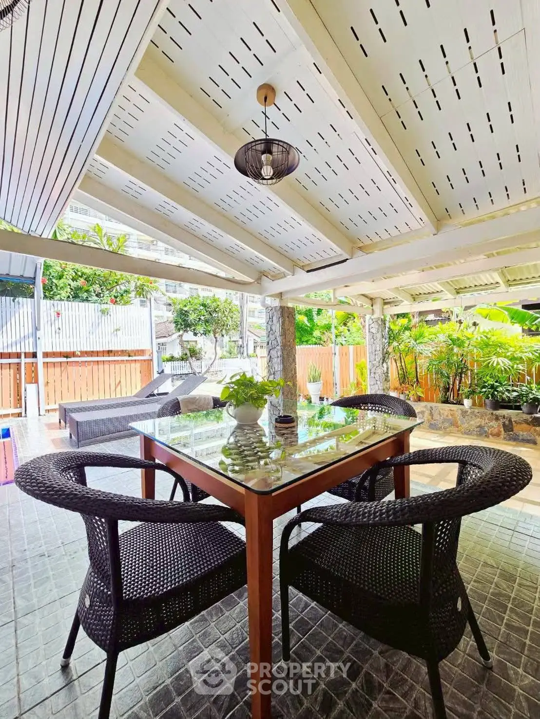 Charming outdoor patio with stylish furniture and lush greenery, perfect for relaxation and entertaining.