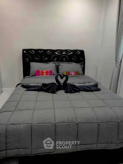 Cozy bedroom with stylish black headboard and elegant swan towel decor