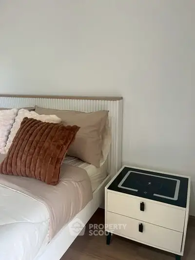 Cozy bedroom with stylish bed and modern nightstand, perfect for relaxation.