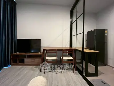 Modern living room with sleek furniture and stylish partition, featuring a TV and dining area.