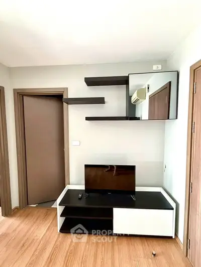 Modern living room with sleek TV stand and floating shelves, perfect for contemporary urban living.