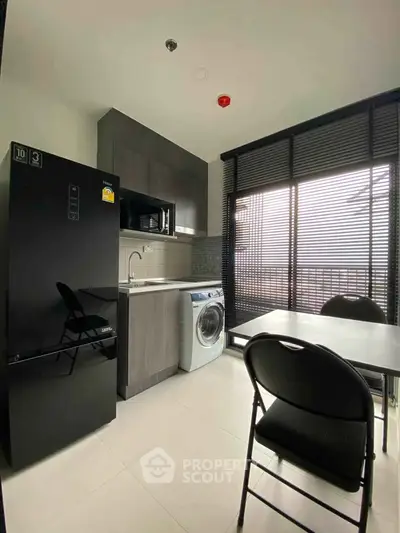Modern kitchen with sleek appliances and large window for natural light