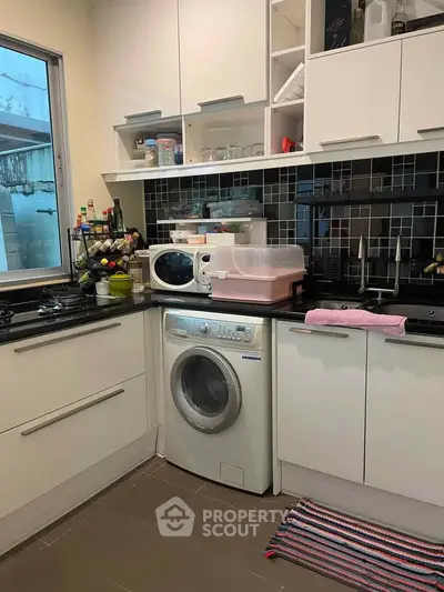 Modern kitchen with washing machine and sleek cabinetry