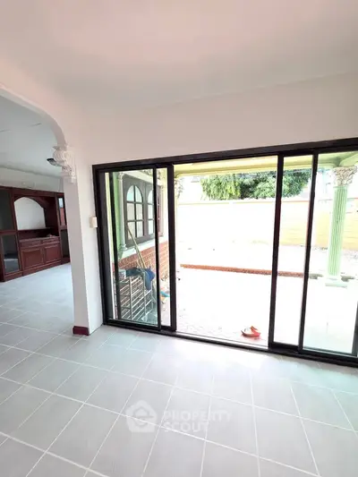 Spacious interior with sliding glass doors leading to a bright outdoor area, perfect for natural light.