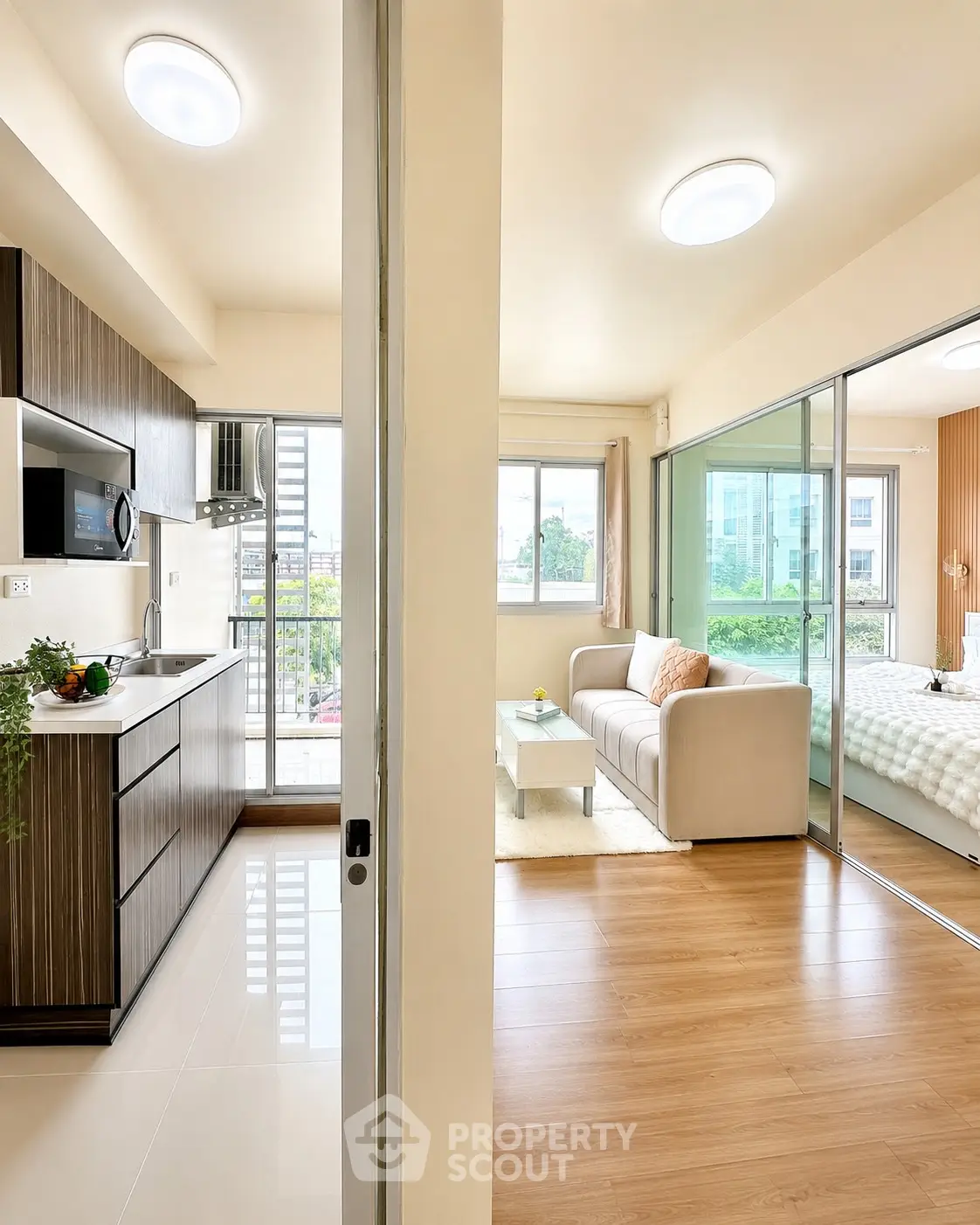 Modern open-plan kitchen and living room with balcony view in a stylish apartment.