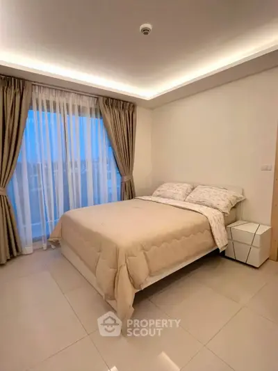 Modern bedroom with elegant lighting and large window, offering a cozy and inviting atmosphere.