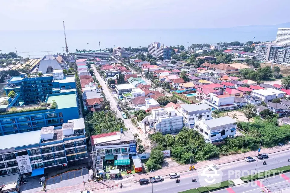 Stunning aerial view of coastal cityscape with vibrant buildings and ocean backdrop, ideal for real estate investment.