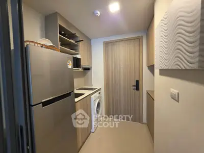 Modern kitchen with sleek appliances and stylish cabinetry in a compact layout.
