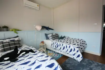 Charming bedroom with twin beds and playful whale-themed decor, perfect for a cozy family home.