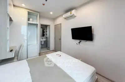 Modern bedroom with sleek design, featuring built-in wardrobe, wall-mounted TV, and air conditioning.
