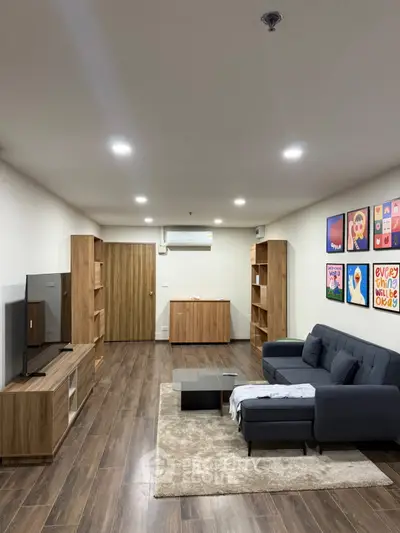 Spacious modern living room with stylish furniture and wooden flooring, perfect for relaxation and entertainment.