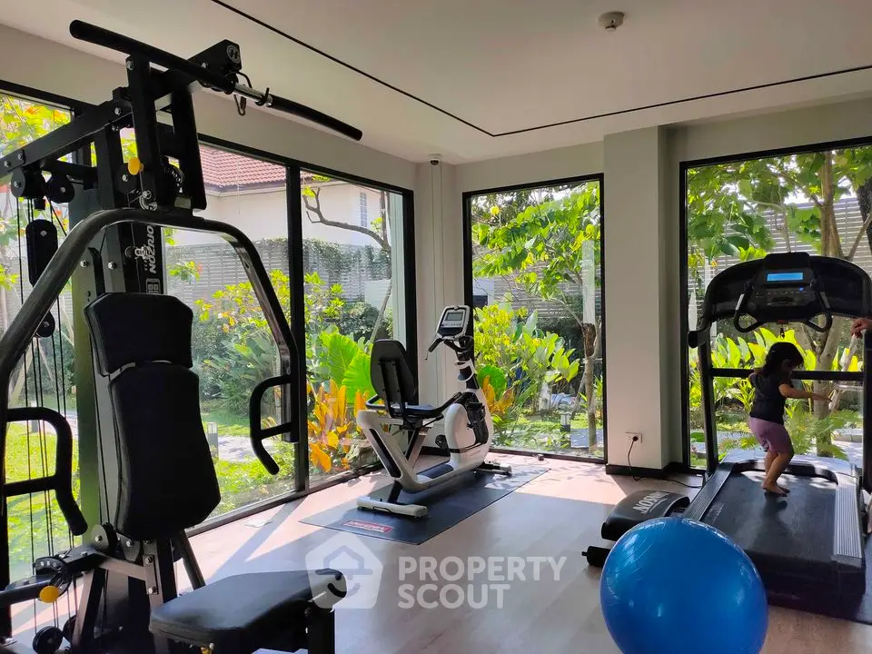 Modern home gym with large windows and garden view