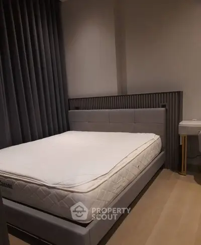 Modern bedroom with stylish gray decor and comfortable bed in a cozy apartment.