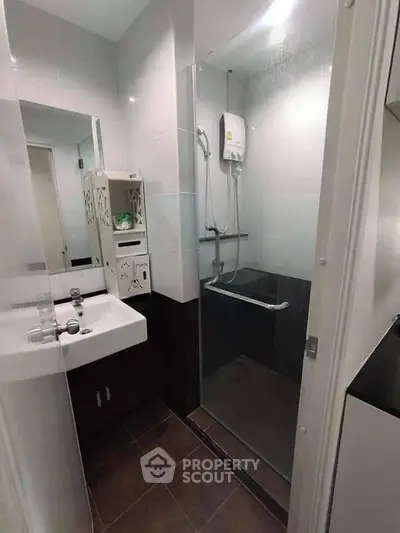 Modern bathroom with sleek shower and stylish sink in compact design.