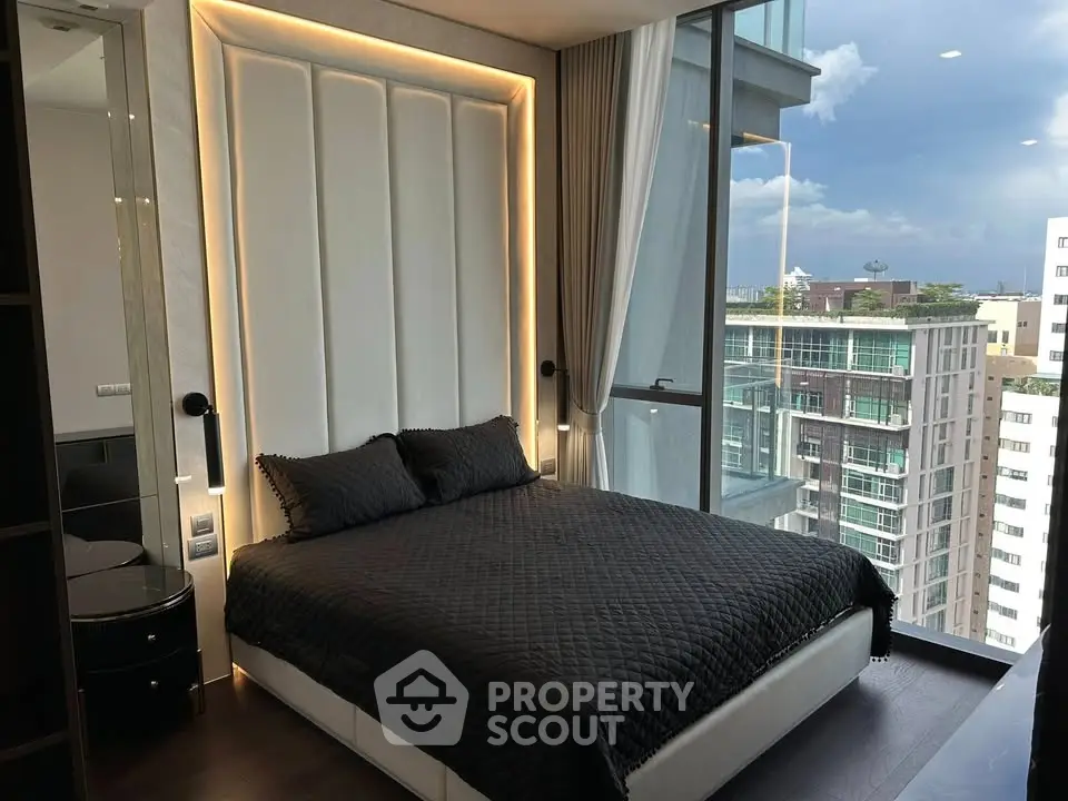 Luxurious bedroom with floor-to-ceiling windows offering stunning city views in a modern high-rise apartment.
