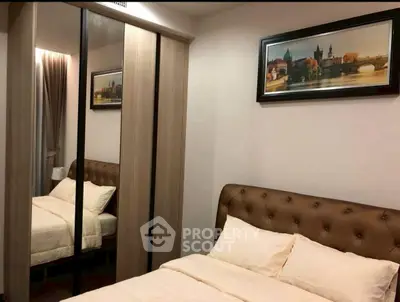 Cozy bedroom with elegant decor and mirrored wardrobe in modern apartment.